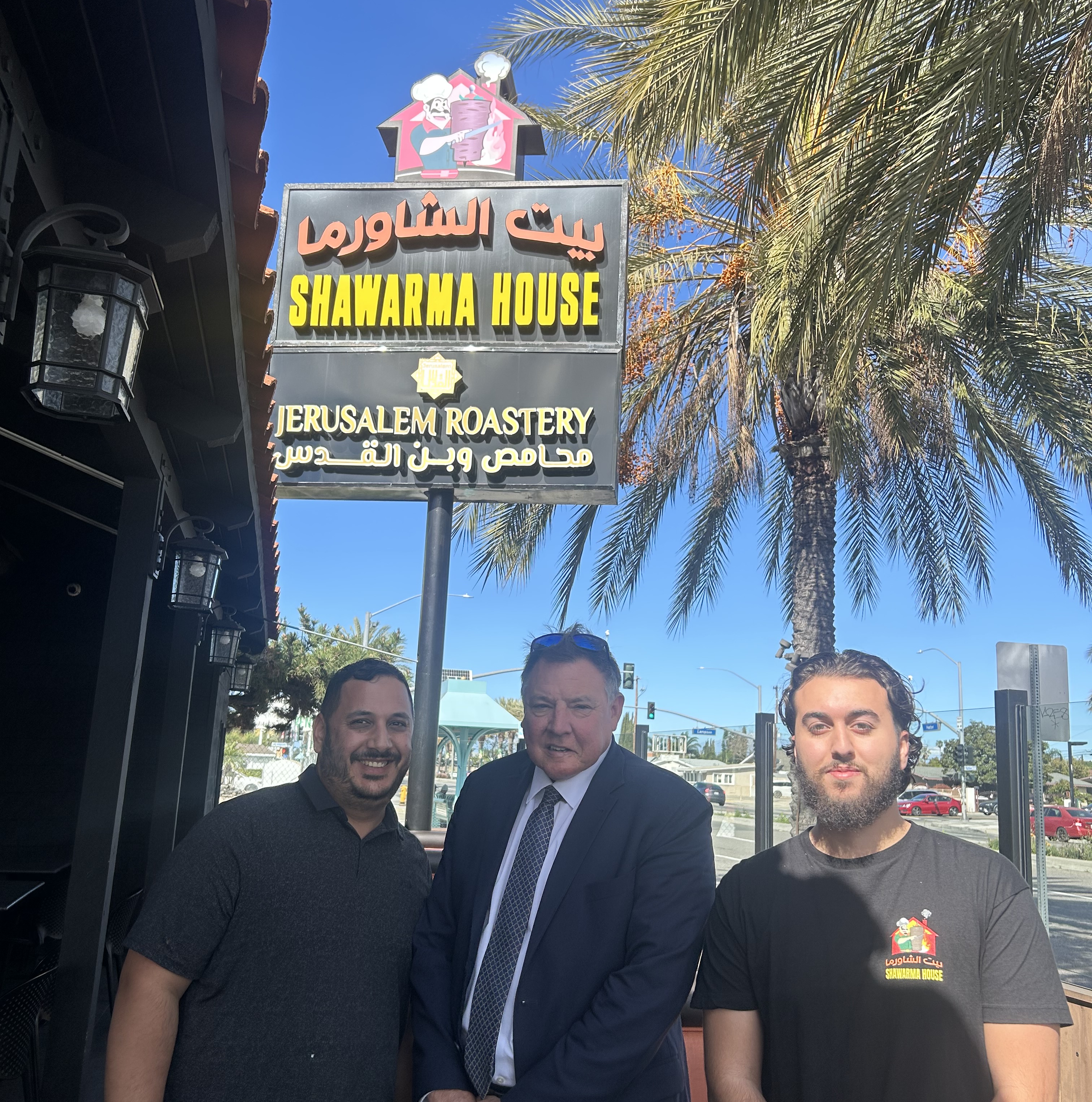 Team members in front of the Shawarma House and Jerusalem Roastery sign in Garden Grove