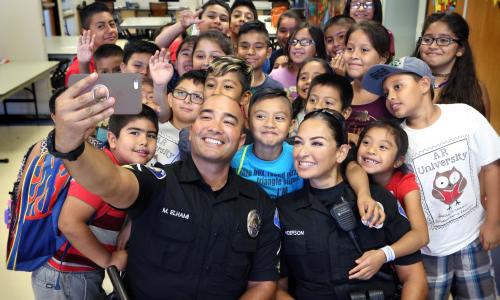 Image of police officers taking a photo with local students.