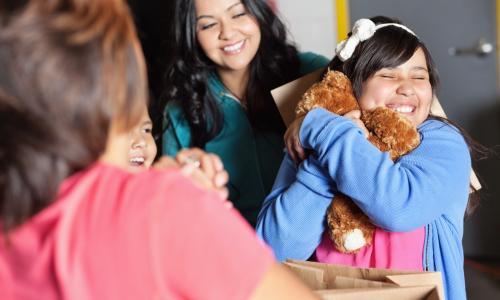 Promotional photo of a girl hugging a teddy bear.