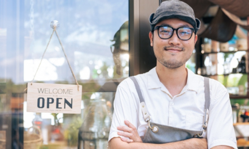 Small business owner standing in front of their store