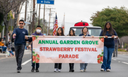 Children holding a banner and leading the Garden Grove Strawberry Festival Parade
