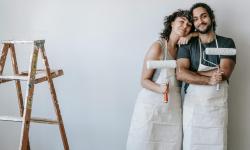 Couple painting interior wall