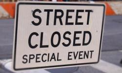 A street sign, announcing a special event street closure.