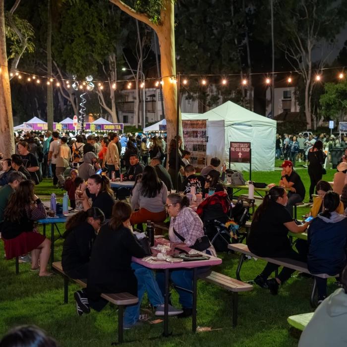 A crowd of people eating at a food festival